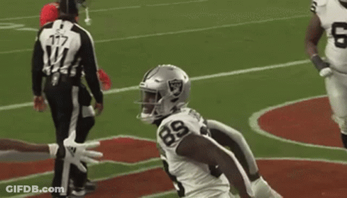 A Football Player Wearing A White Jersey With The Number 89 On It Is Standing On A Field . GIF