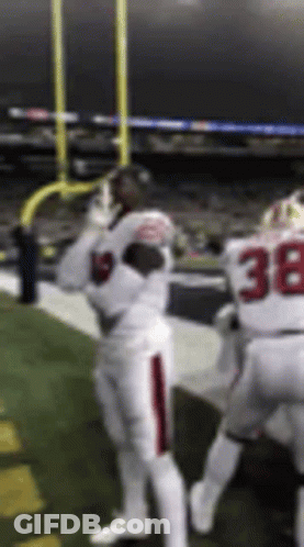 A Football Player Wearing A White Uniform With The Number 38 On It Is Standing On A Field . GIF