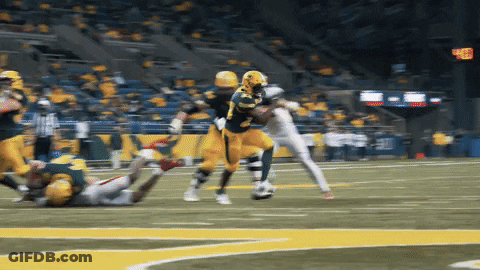 A Football Player Wearing A Yellow Jersey With The Number 28 On It Is Being Tackled GIF