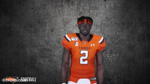 A Football Player Wearing An Orange Jersey With The Number 2 GIF