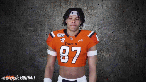 A Football Player Wearing An Orange Jersey With The Number 87 GIF