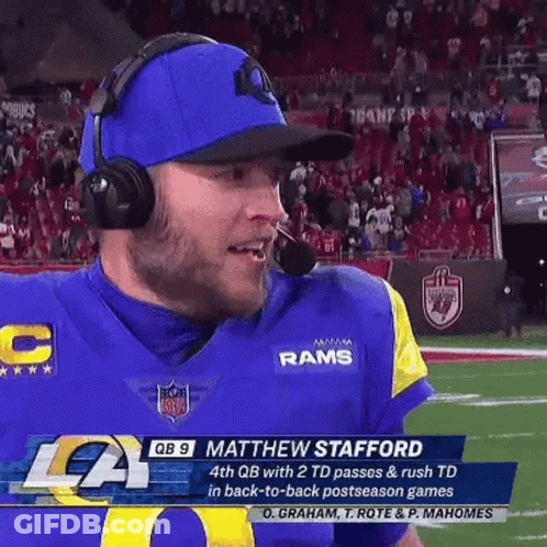 A Football Player Wearing Headphones And A Blue Hat Is On The Field . GIF