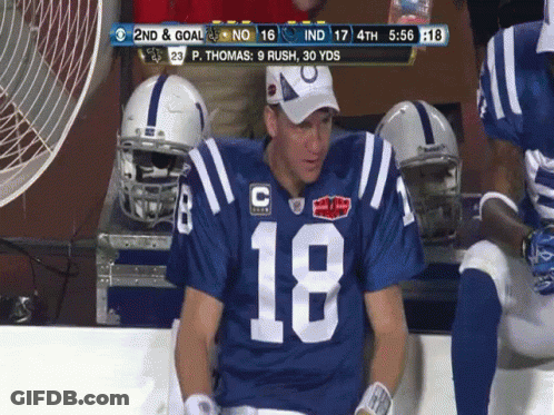 A Football Player Wearing Number 18 Sits On The Bench GIF