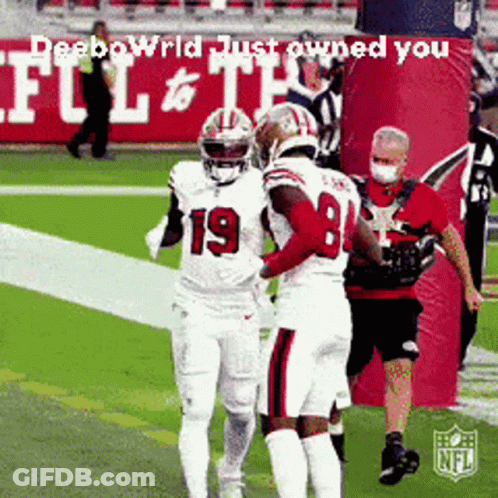 A Football Player Wearing Number 19 Is Hugging Another Player On The Field GIF