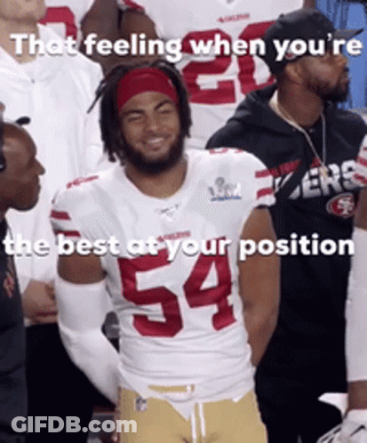 A Football Player Wearing Number 54 Is Smiling In Front Of His Teammates GIF