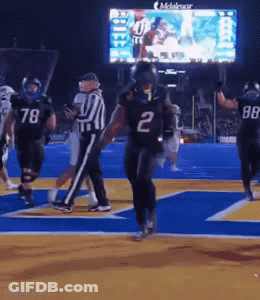 A Football Player Wearing The Number 2 Jersey Is Running On The Field GIF