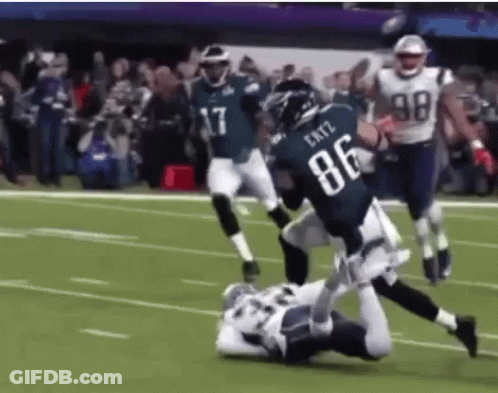 A Football Player Wearing The Number 86 Is Being Tackled By Another Player GIF