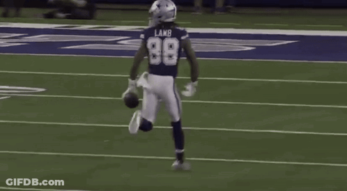 A Football Player Wearing The Number 98 Is Running On The Field . GIF