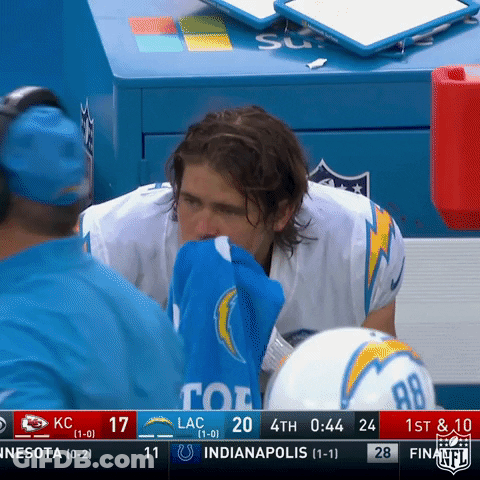 A Football Player Wipes His Nose With A Blue Towel During A Game GIF