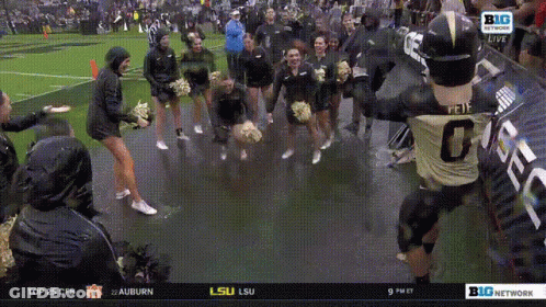 A Football Player With The Number 0 On The Back Of His Jersey Is Surrounded By Cheerleaders GIF