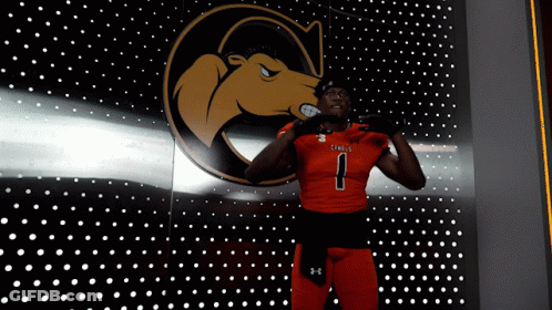 A Football Player With The Number 1 On His Jersey Stands In Front Of A Wall With Dots GIF
