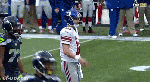 A Football Player With The Number 10 On His Jersey Is Standing On The Field . GIF