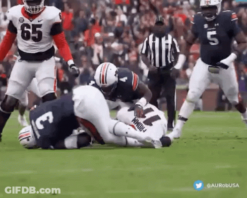 A Football Player With The Number 11 On His Jersey Is Being Tackled By Another Player . GIF