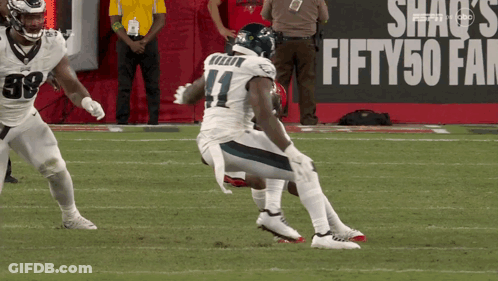 A Football Player With The Number 11 On His Jersey Is Kneeling On The Field GIF