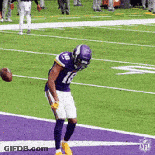 A Football Player With The Number 12 On His Jersey Catches A Ball GIF