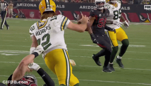 A Football Player With The Number 12 On His Jersey Is Running With The Ball GIF