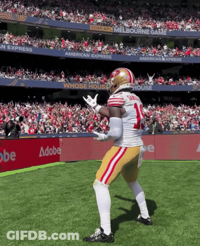 A Football Player With The Number 14 On His Jersey Is Dancing On The Field GIF
