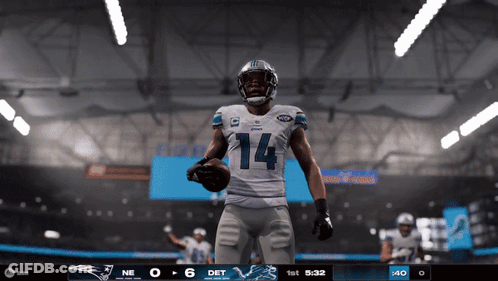 A Football Player With The Number 14 On His Jersey Is Holding A Ball GIF
