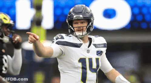 A Football Player With The Number 14 On His Jersey Points At Something GIF