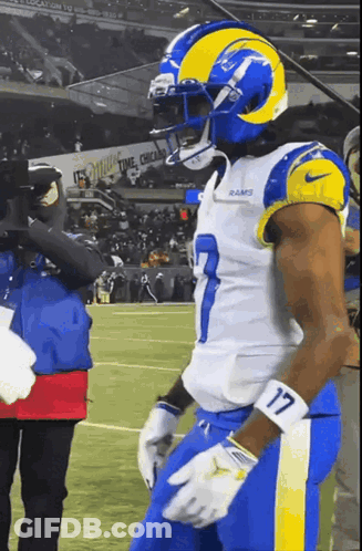 A Football Player With The Number 17 On His Arm Stands On The Field GIF