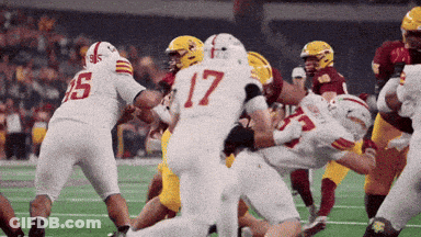 A Football Player With The Number 17 On His Jersey Is Being Tackled GIF