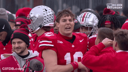 A Football Player With The Number 18 On His Jersey Is Surrounded By Other Players GIF