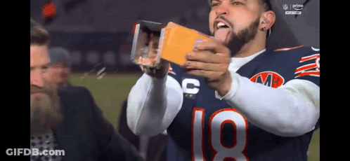 A Football Player With The Number 18 On His Jersey Is Taking A Picture Of Himself GIF
