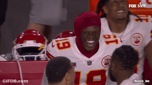 A Football Player With The Number 18 On His Jersey Smiles With His Teammates GIF