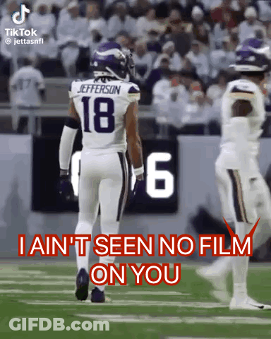 A Football Player With The Number 18 On His Jersey Walks On The Field . GIF