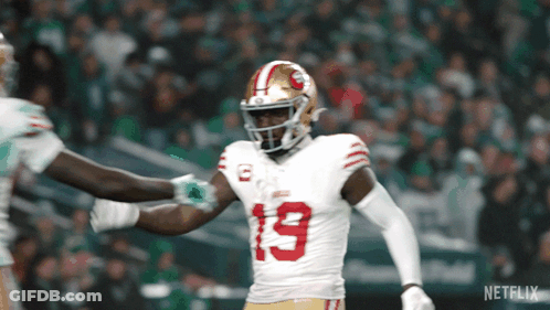 A Football Player With The Number 19 On His Jersey Stands On The Field GIF