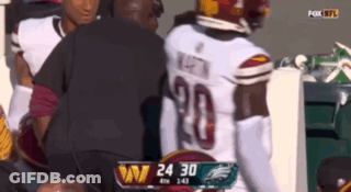 A Football Player With The Number 20 On His Jersey Is Being Helped By A Man GIF