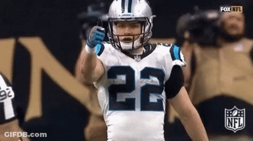 A Football Player With The Number 22 On His Jersey Is Giving A Thumbs Up During A Game . GIF
