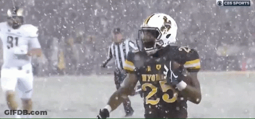 A Football Player With The Number 25 On His Jersey Runs In The Snow GIF