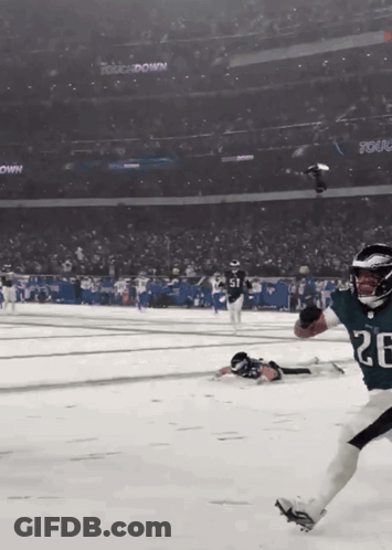 A Football Player With The Number 26 On His Jersey Is Running On A Snowy Field GIF