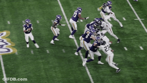 A Football Player With The Number 27 On His Jersey Is Being Tackled GIF