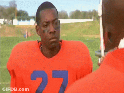 A Football Player With The Number 27 On His Jersey Is Standing On A Field . GIF