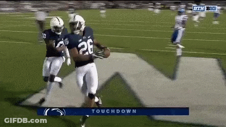 A Football Player With The Number 28 On His Jersey Is Running On A Field GIF