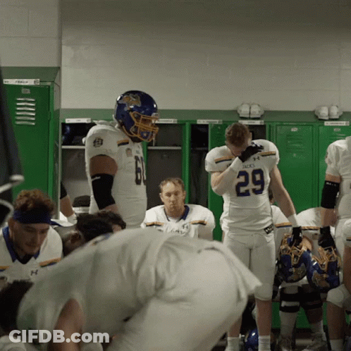 A Football Player With The Number 29 On His Jersey Stands In A Locker Room GIF