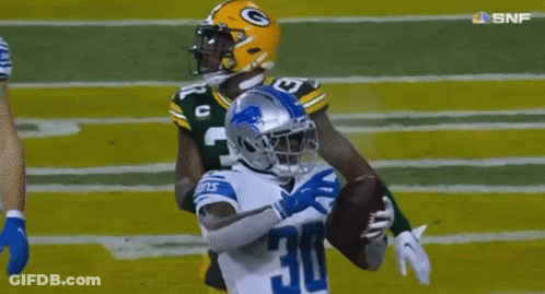 A Football Player With The Number 30 On His Jersey Is Trying To Catch A Ball . GIF