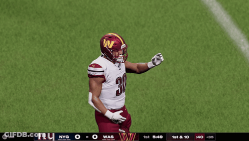 A Football Player With The Number 30 On His Jersey Stands On A Field GIF