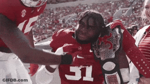 A Football Player With The Number 31 On His Jersey Is Being Helped Off The Field GIF