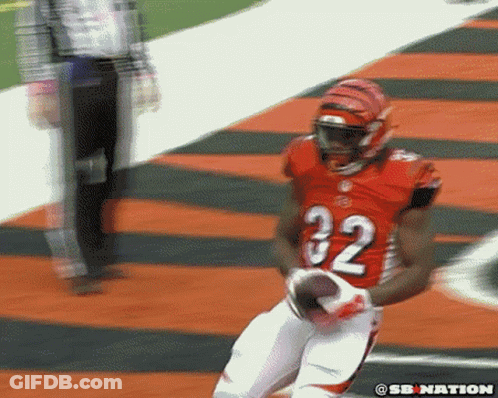 A Football Player With The Number 32 On His Jersey Is Running With The Ball GIF