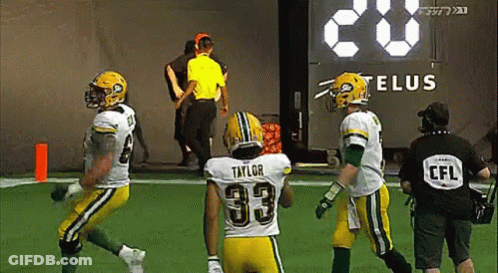 A Football Player With The Number 33 On His Back Is Running On The Field . GIF
