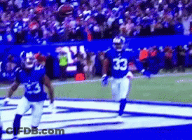A Football Player With The Number 33 On His Jersey Is Running On The Field . GIF