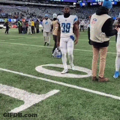 A Football Player With The Number 39 On His Jersey Walks On The Field GIF