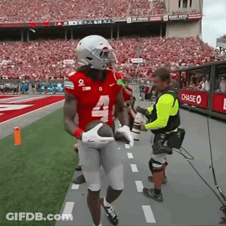 A Football Player With The Number 4 On His Jersey Is Holding A Football GIF