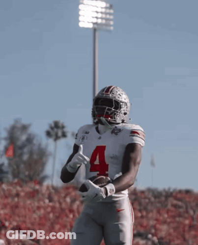 A Football Player With The Number 4 On His Jersey Is Holding A Football GIF