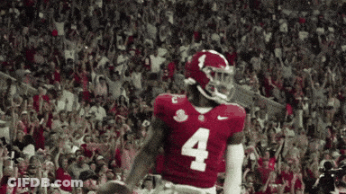 A Football Player With The Number 4 On His Jersey Stands In Front Of A Crowd GIF