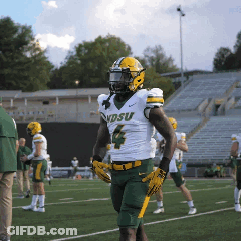 A Football Player With The Number 4 On His Jersey Stands On A Field GIF