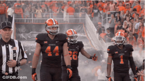 A Football Player With The Number 44 On His Jersey Walks With Two Other Players GIF